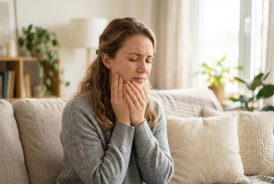 Kobieta trzymająca się za twarz, odczuwająca silny ból szczęki i żuchwy.