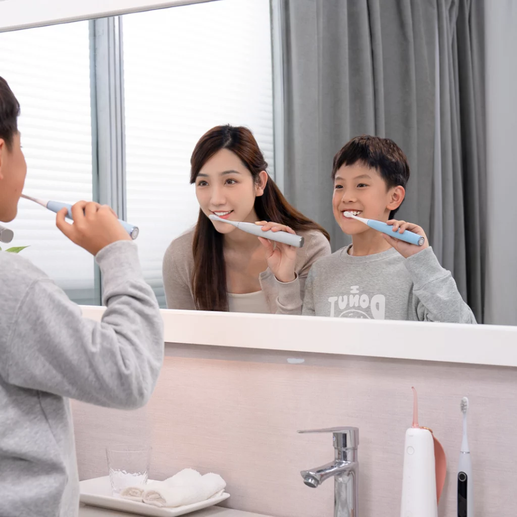 Dziecko myje zęby przy pomocy szczoteczki sonicznej